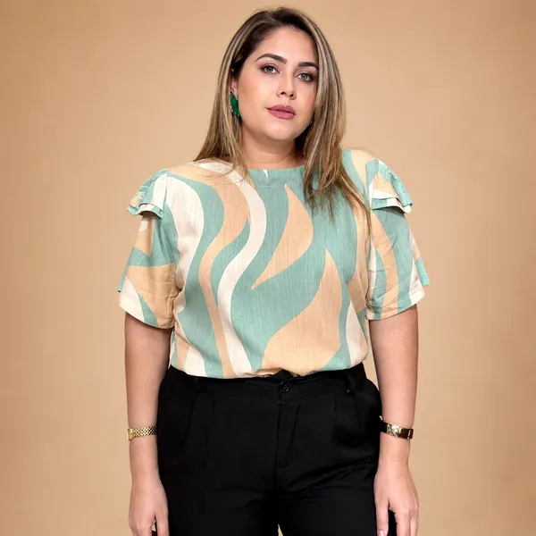 Modelo plus size veste blusa estampada verde e bege com manga babado e calça preta