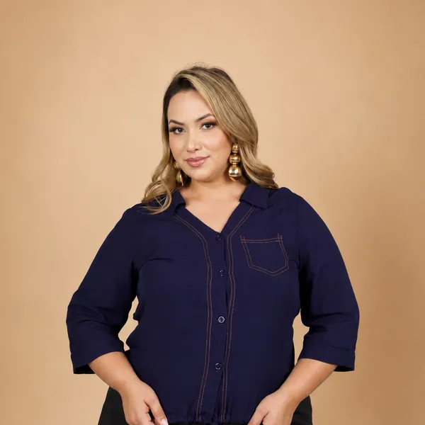 Modelo plus size veste camisa azul marinho com pesponto laranja e amarração na barra